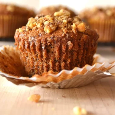 Freshly baked banana nut muffins with walnuts on a rustic wooden table