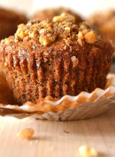 Freshly baked banana nut muffins with walnuts on a rustic wooden table