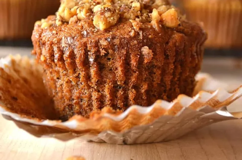 Freshly baked banana nut muffins with walnuts on a rustic wooden table
