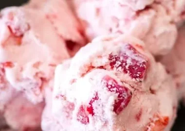 Creamy homemade strawberry ice cream topped with fresh strawberries