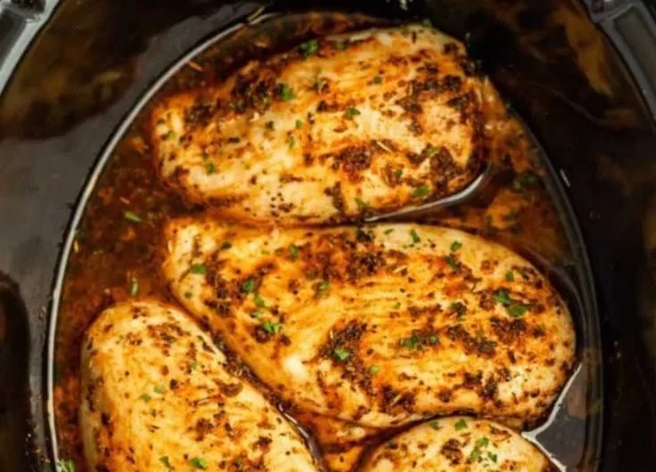 Tender slow cooker chicken breasts ready to serve with herbs and spices