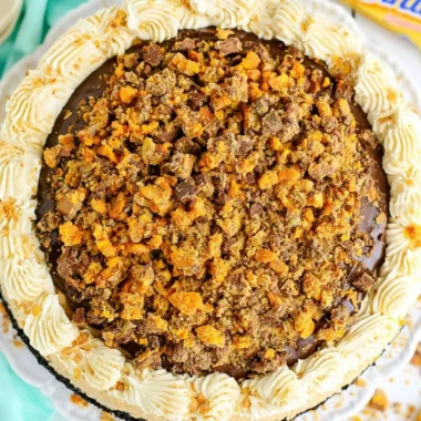 Delicious Butterfinger Cheesecake topped with crushed Butterfinger candy bars