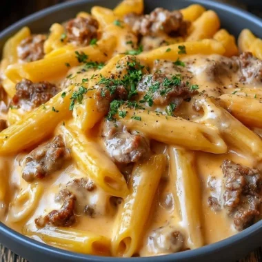 Creamy beef pasta served in a bowl, garnished with herbs and cheese.