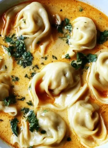 Bowl of creamy Thai dumpling soup with vibrant herbs and fresh dumplings