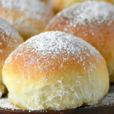 Freshly baked easy potato rolls placed on a wooden table.