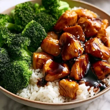 Plate of teriyaki chicken with broccoli garnished with sesame seeds