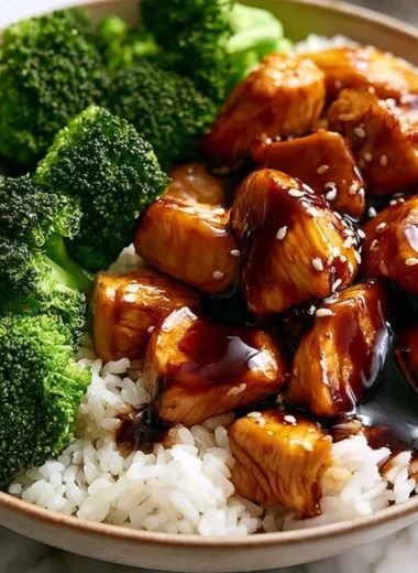 Plate of teriyaki chicken with broccoli garnished with sesame seeds