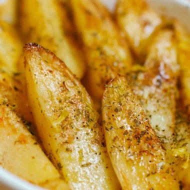Delicious Greek lemon potatoes served with fresh herbs and lemon slices
