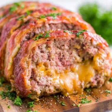 Delicious smoked meatloaf served on a wooden board with herbs