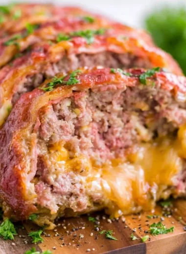 Delicious smoked meatloaf served on a wooden board with herbs