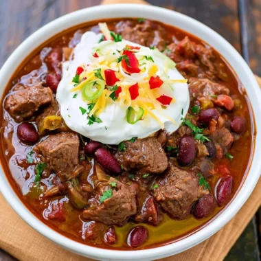 Delicious bowl of spicy steak chili garnished with fresh herbs