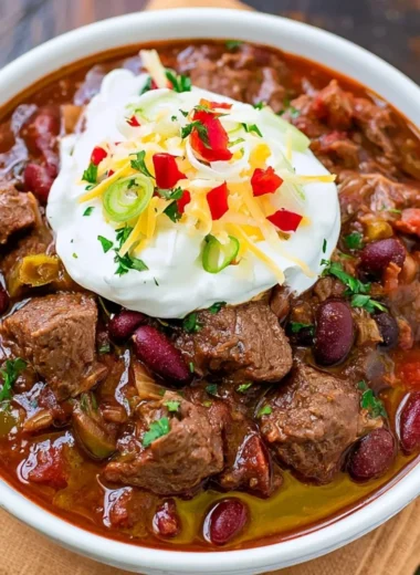 Delicious bowl of spicy steak chili garnished with fresh herbs
