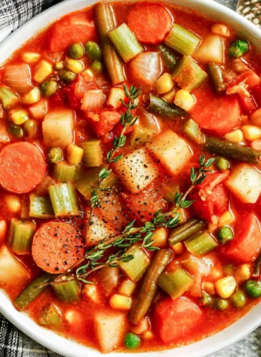 Bowl of hearty vegetable soup with colorful fresh vegetables