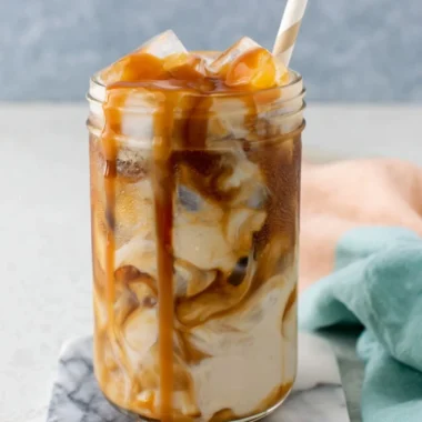 Homemade caramel iced coffee served in a glass with ice and caramel drizzle
