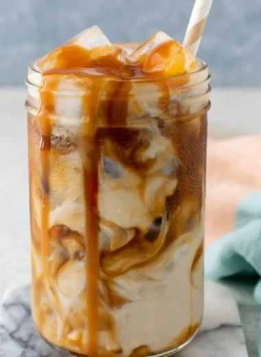 Homemade caramel iced coffee served in a glass with ice and caramel drizzle