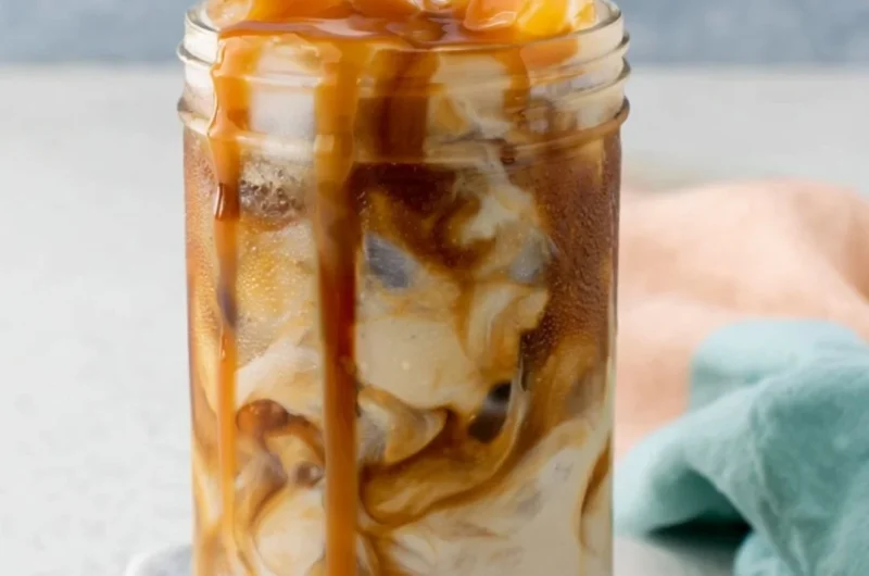 Homemade caramel iced coffee served in a glass with ice and caramel drizzle