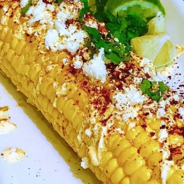 Mexican corn elotes topped with cheese and chili powder