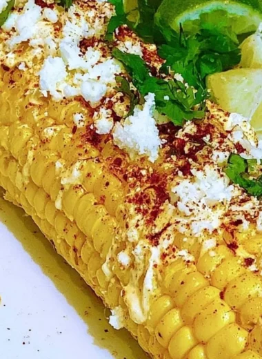 Mexican corn elotes topped with cheese and chili powder