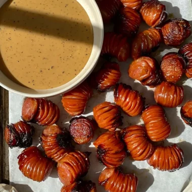 Easy gameday sausage appetizer served on a platter with sauce and garnish.