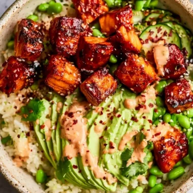 Honey Sriracha Salmon Bowls garnished with vegetables and served in a bowl
